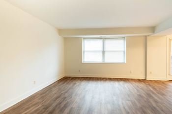 a bedroom with hardwood floors and a window  at Charlesgate Apartments, Towson, Maryland
